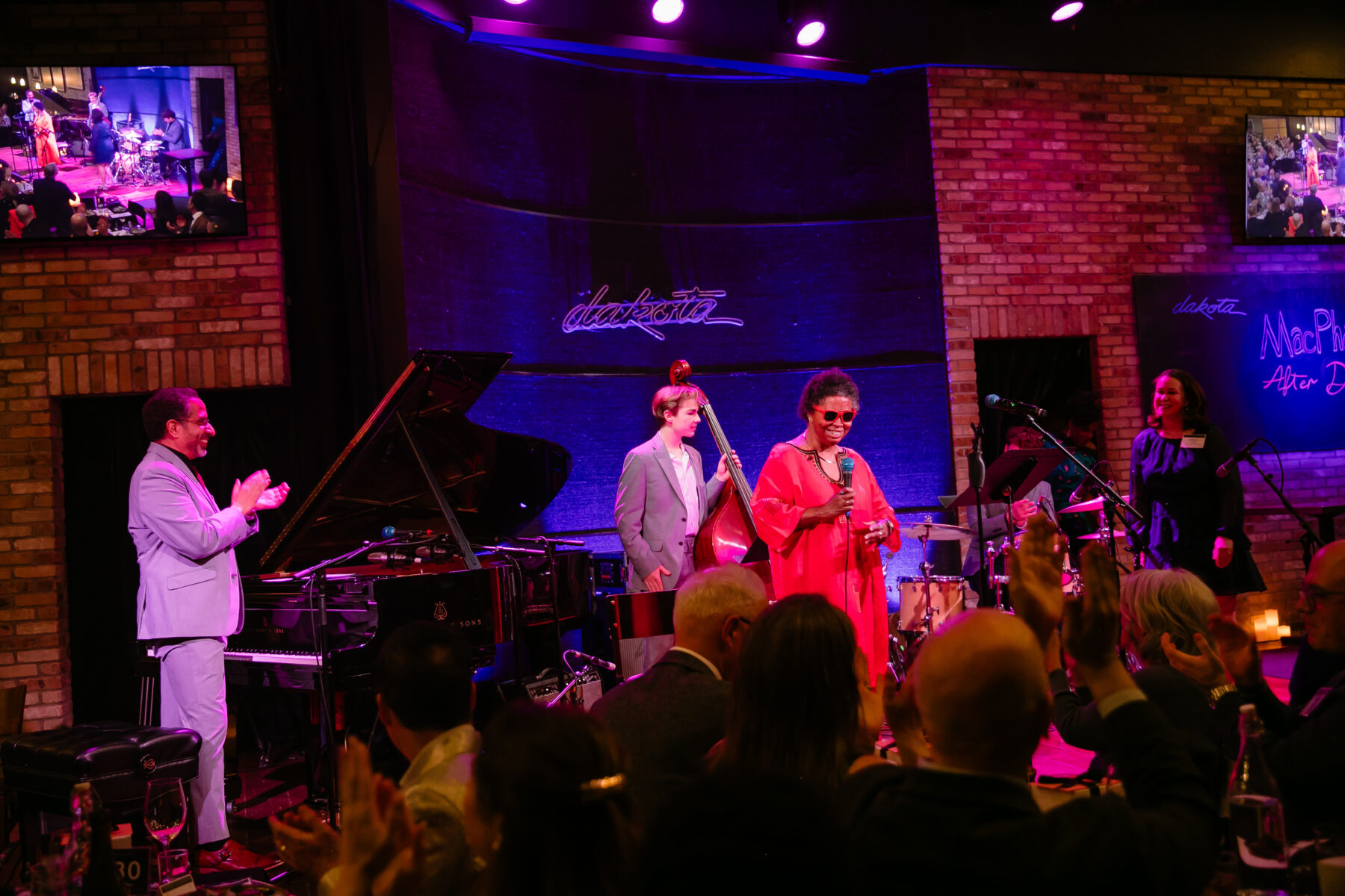 A smiling student gives a testimonial onstage at the dakota