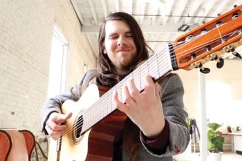 Person with long hair playing a guitar