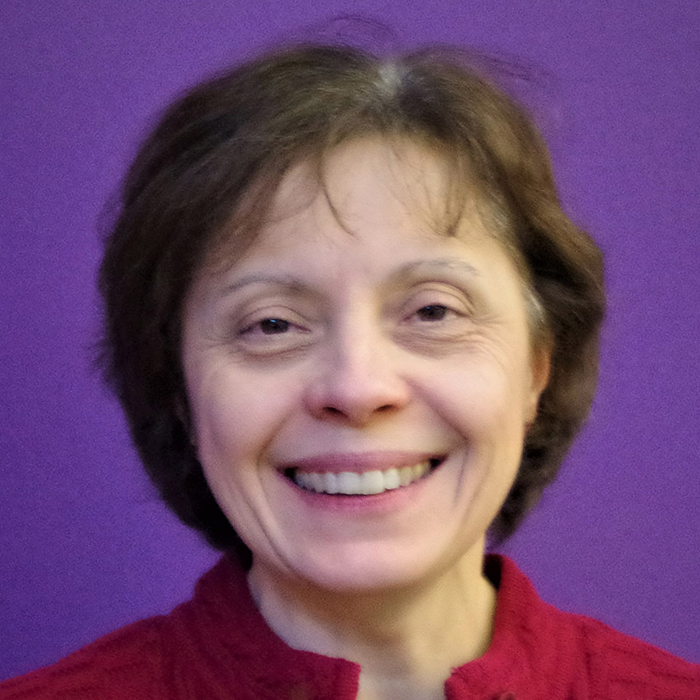 Person wearing a red shirt with a purple background behind them