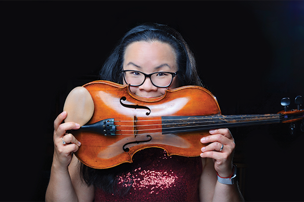 Person holding a horizontal violin up to their face