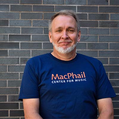 Paul standing in front of a brick wall