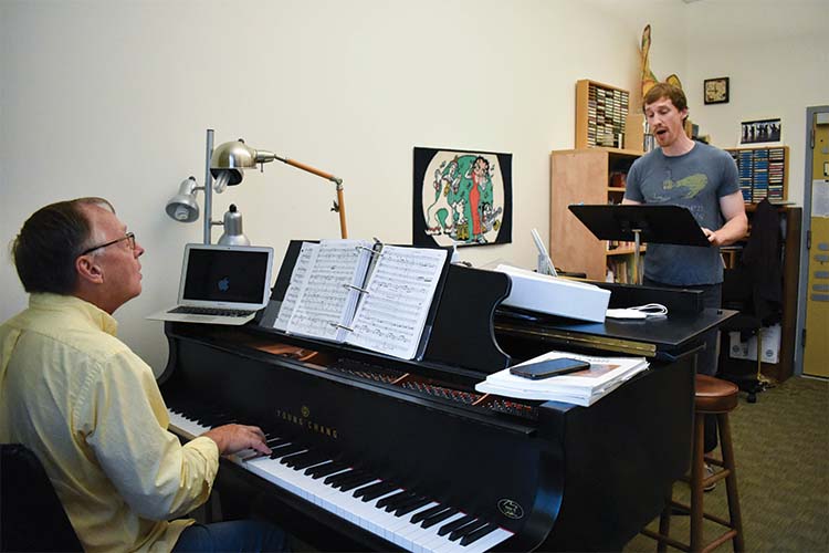 Teacher playing a piano while a student sings