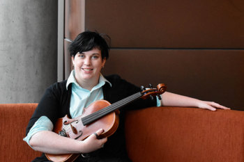 Person with short dark hair, holding a violin