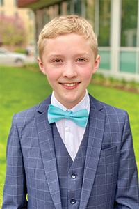 Young student wearing a blue bow tie and gray suit