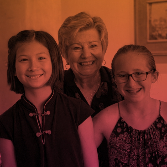 Two students standing and smiling with teacher