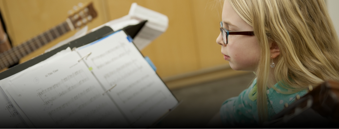 student playing a guitar