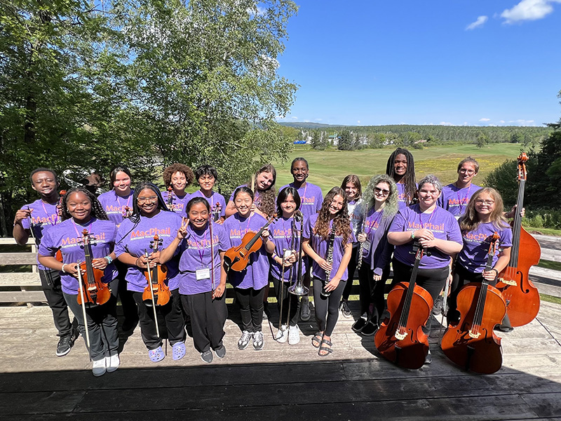 youth orchestra members pose for a group photo outdoors at Madeline Island