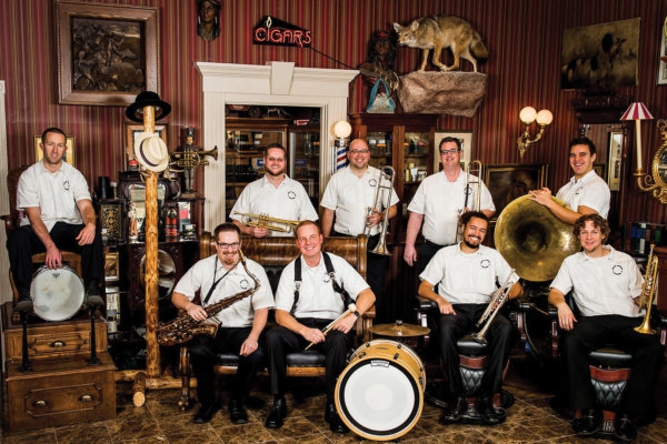 Group of performers sitting together holding their instruments