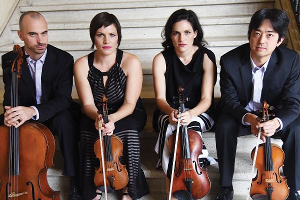 4 adults sitting on stairs. They are each holding a string instrument