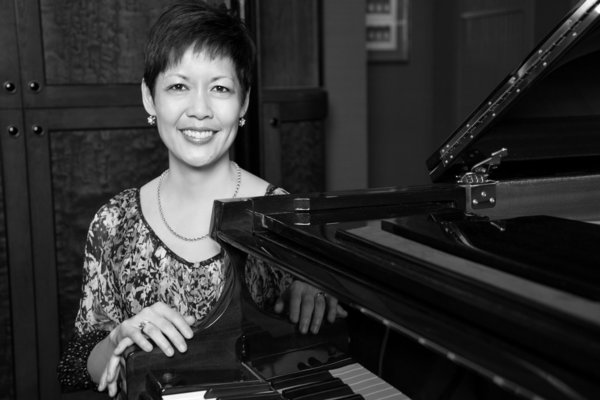 Annette leaning against a piano