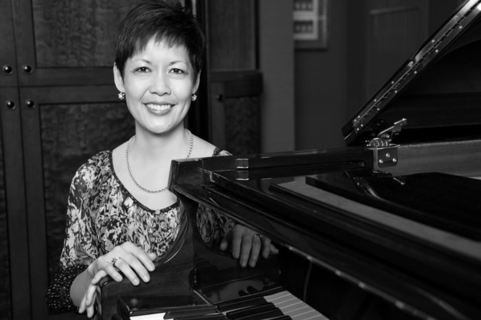 Annette leaning against a piano