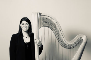 Headshot of Nikki Lemire. She is standing next to a harp.