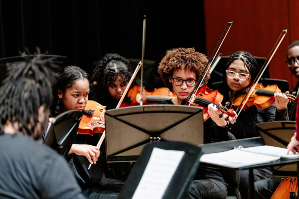 string section of youth orchestra performing