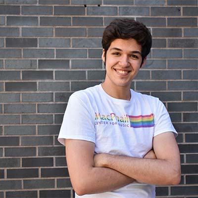 Julian standing in front of a brick wall