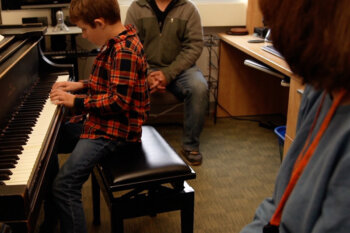 Matt Kassanchuck watches Colby taking piano lesson from Diana Bearmon