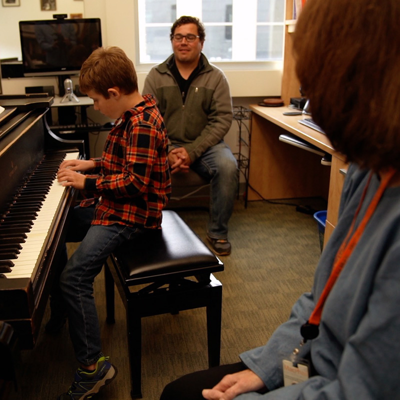 Matt Kassanchuck watches Colby taking piano lesson from Diana Bearmon