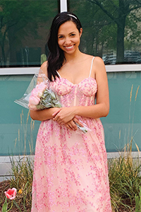 Student wearing a pink dress and holding a bouquet of flowers