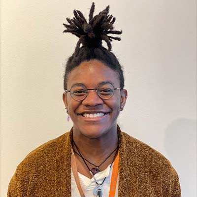 Person wearing round glasses and smiling