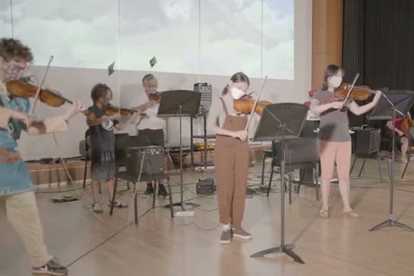 Students playing violin on stage 