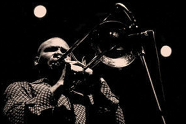 Black and white photo of Robin Eubanks playing trumpet