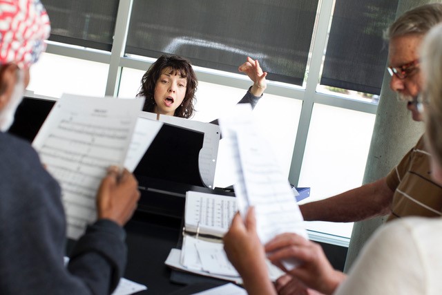 Teacher and a group of adult students singing