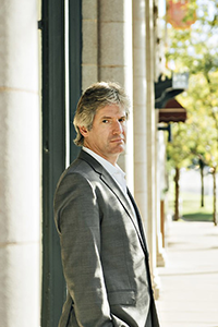 Person wearing a gray suit, standing outside