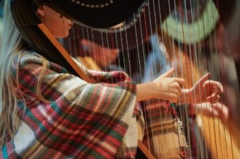 student's hands playing harp