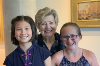 Two students standing with their teacher