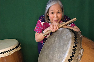 Iris leaning over a Taiko Drum.