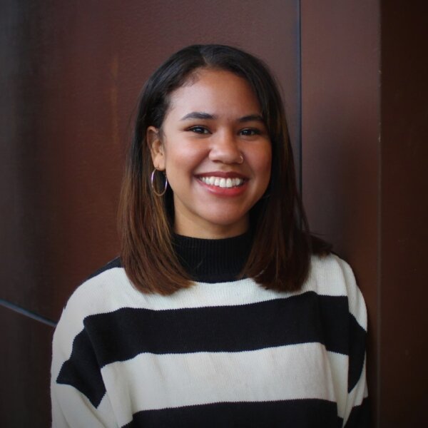 Person with pink, short hair smiling