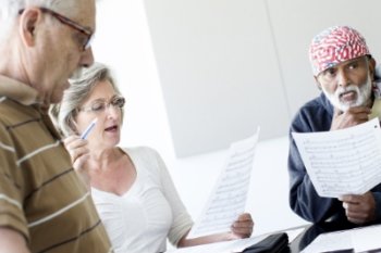 3 people lookin at sheet music