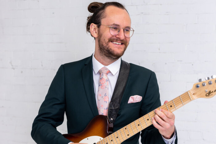 Faculty member Tommy Boynton with an electric guitar