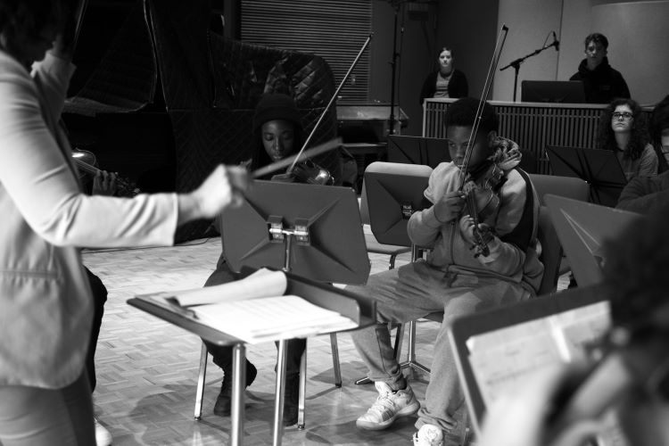 Teacher conducting an orchestra of students