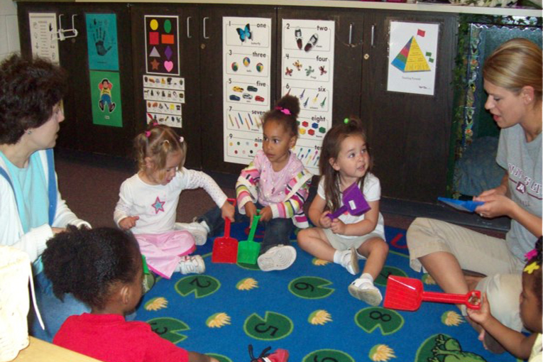 Group of young students and two teachers in a classroom