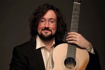 Christopher holding a guitar