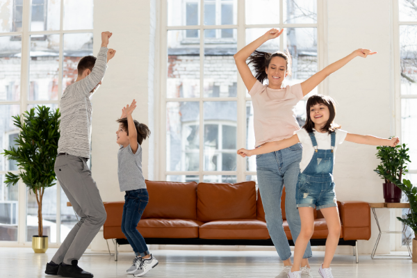 Two adults and two kids dancing at home