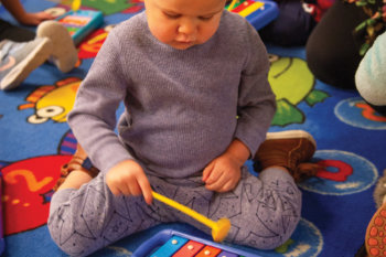 baby playing a small xylophone