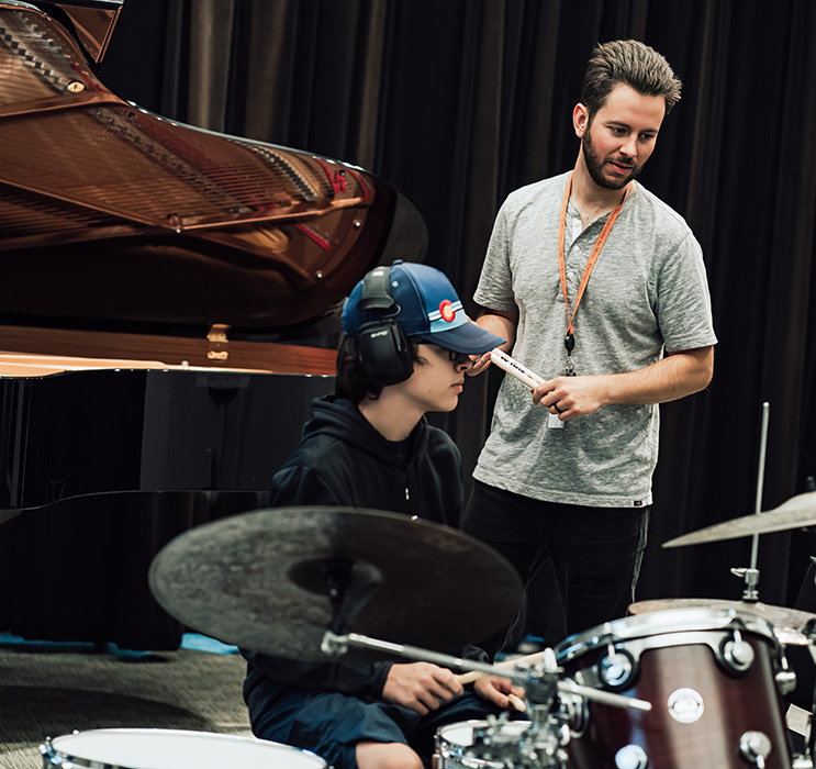 Erik Schee instructs a student on the drum set.