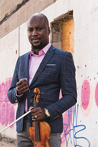 Ernest standing, holding a violin