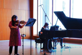 A person playing piano and a person playing violin