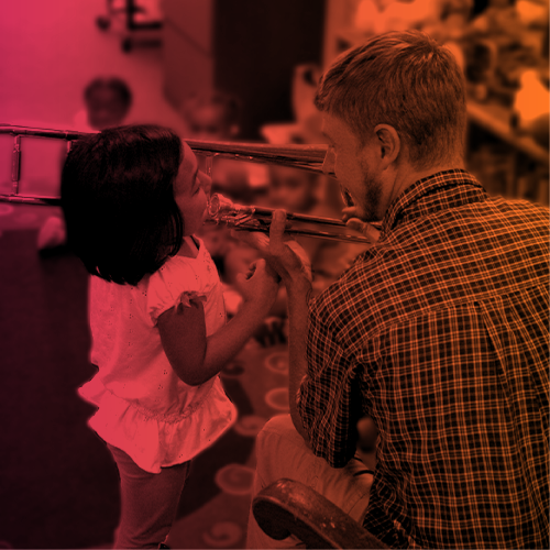 Teacher showing a young child a trombone