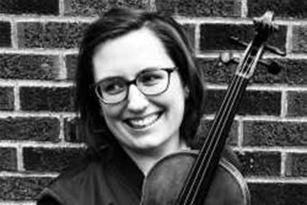 Black and white photo of a person holding a violin