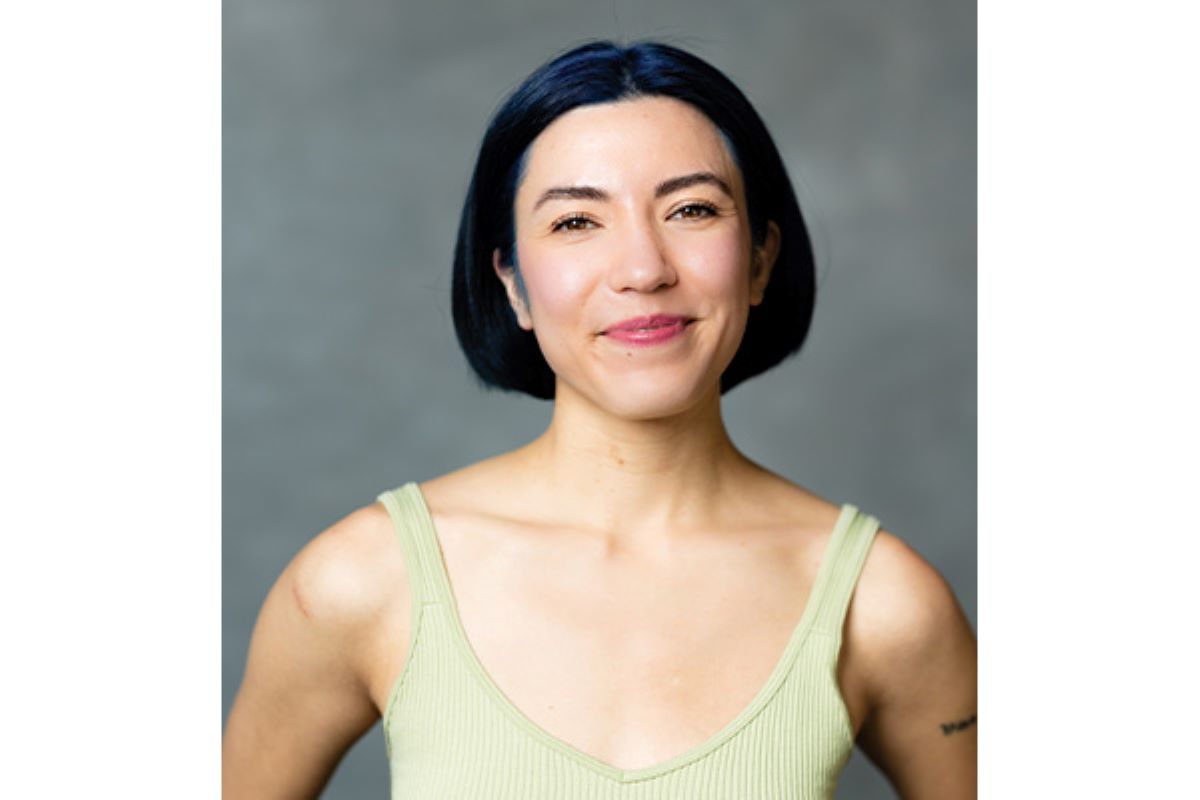 Person with short dark hair wearing a green tank top