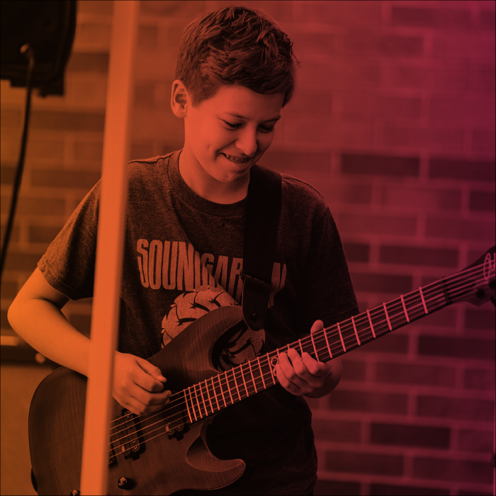 Young student playing an electric guitar