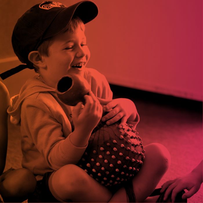 A young student sitting and holding an instrument