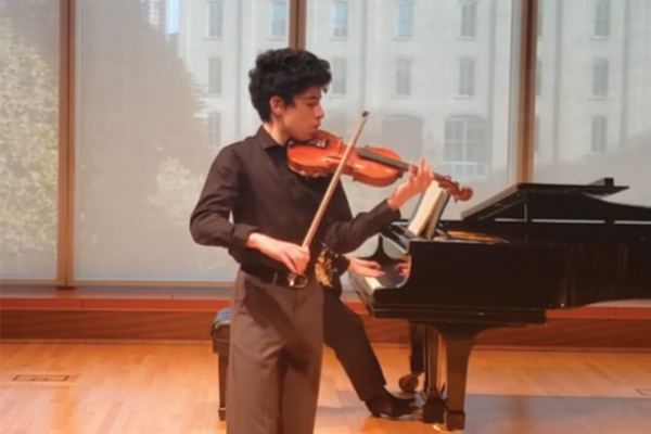 Student playing violin on stage