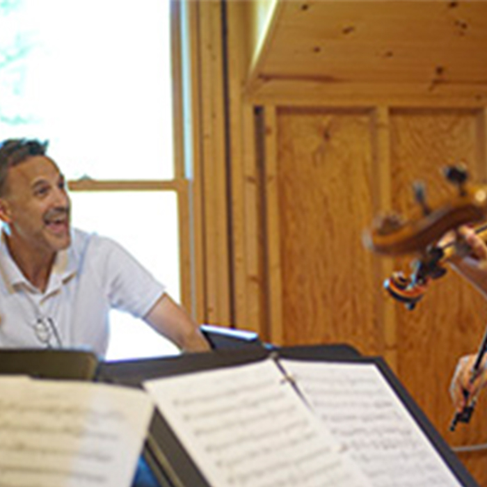 Teacher and a group of students playing violin