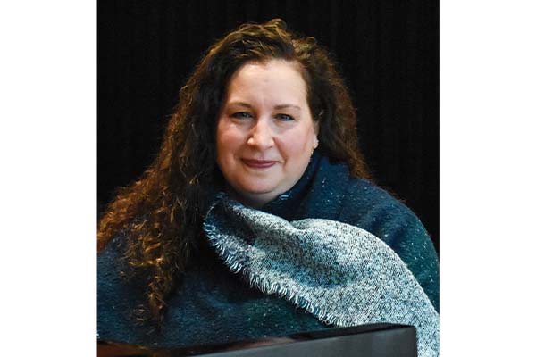 Person with long curly hair wearing a blue scarf