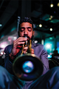 Head on view of Omar playing a trumpet