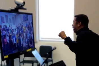 Teacher teaching a class on a tv screen